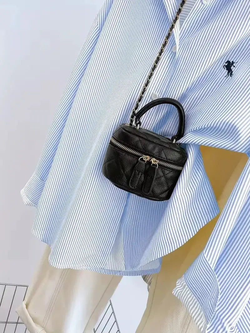 women's blue and white striped button-up blouse with a small black quilted handbag