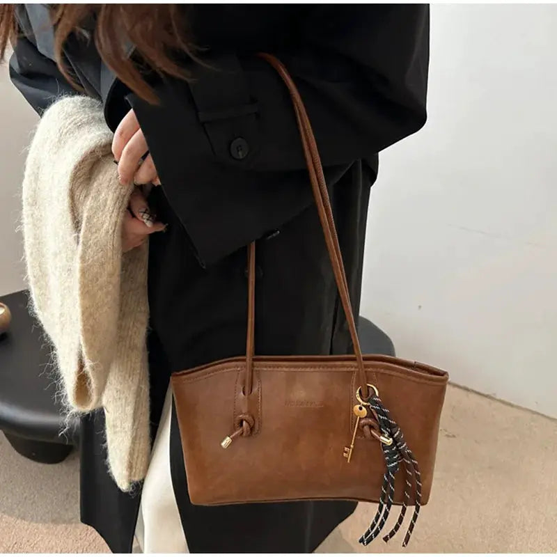 European American retro tote bag in brown leather with long shoulder straps and pendant tassels