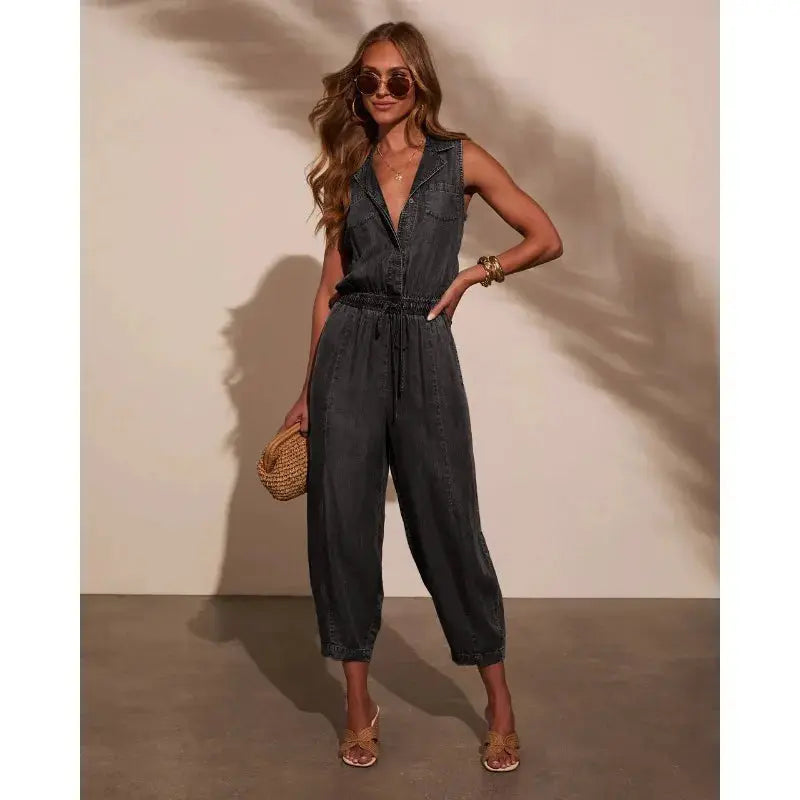 Women's sleeveless denim jumpsuit with drawstring waist, pockets, and front buttons in dark wash