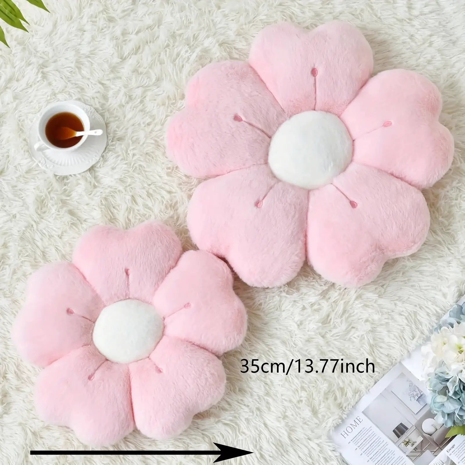 Two pink flower-shaped plush throw pillows by Simples Market with white centers on a white shag rug.
