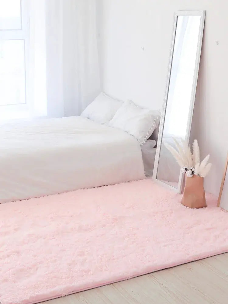 Kids pink fluffy shag rug for bedroom, soft pastel floor mat beside a white bed and a full-length mirror