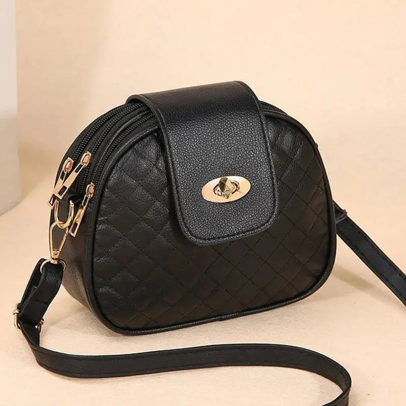 Compact quilted oval crossbody bag in black PU leather with multi-layer zipper storage and gold hardware.