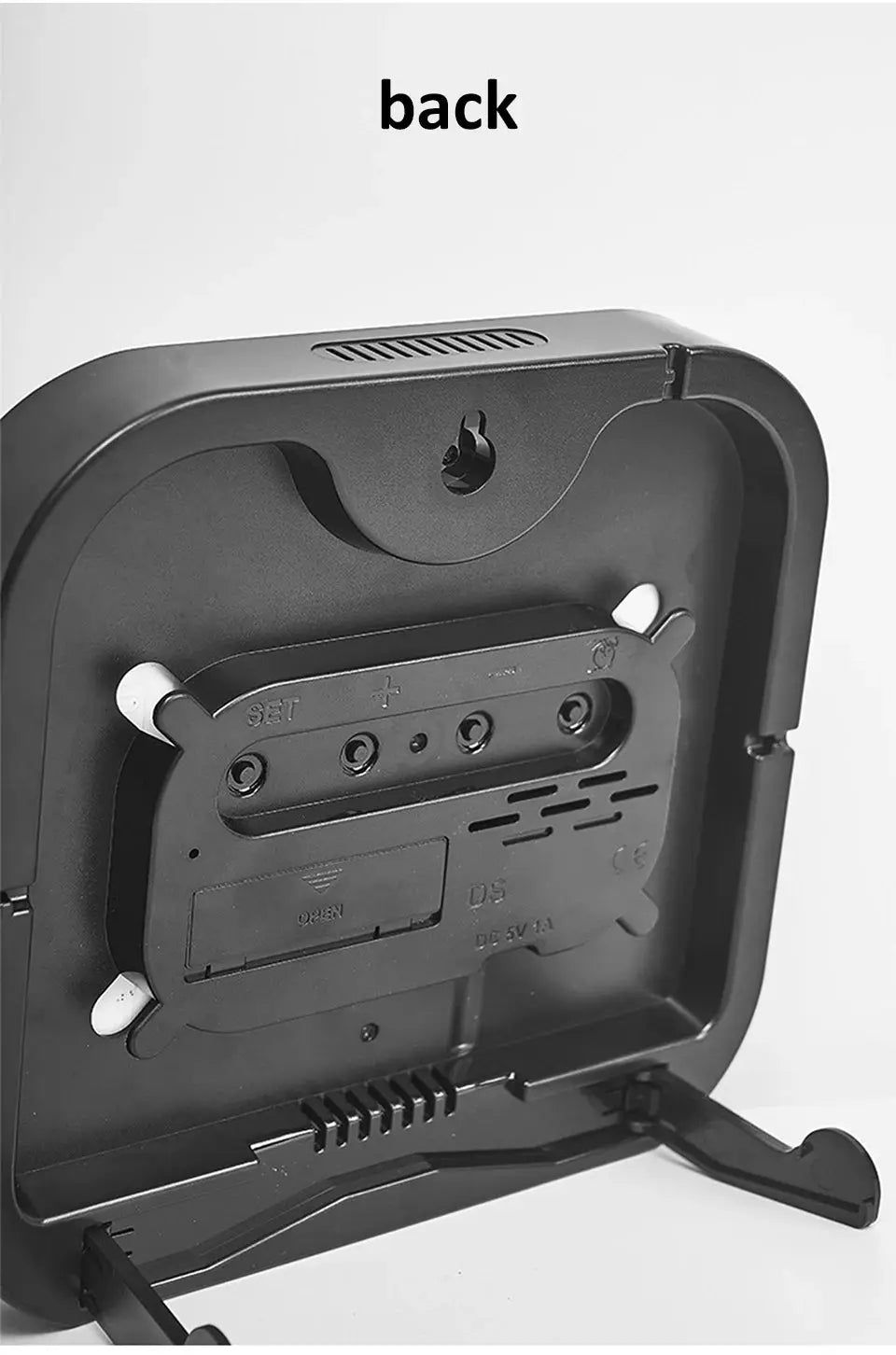 Back view of a black mirror-brushed finish wall clock with battery compartment and fold-out stand.