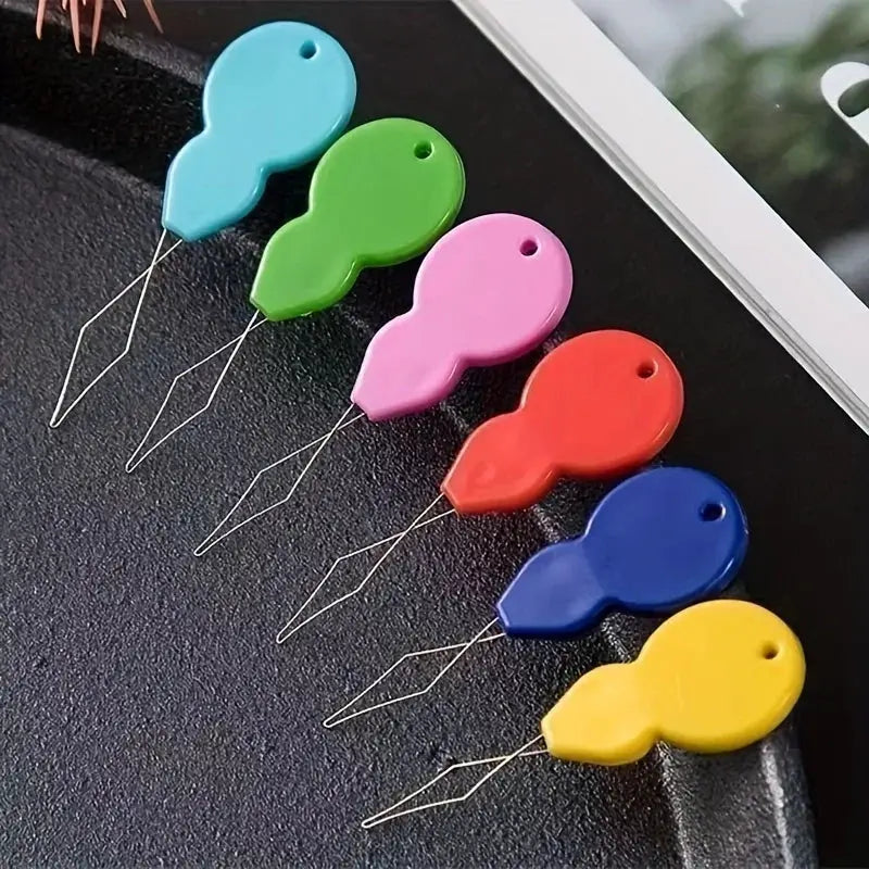 Plastic needle threaders in six colors by Simples Market with diamond-shaped wire loops