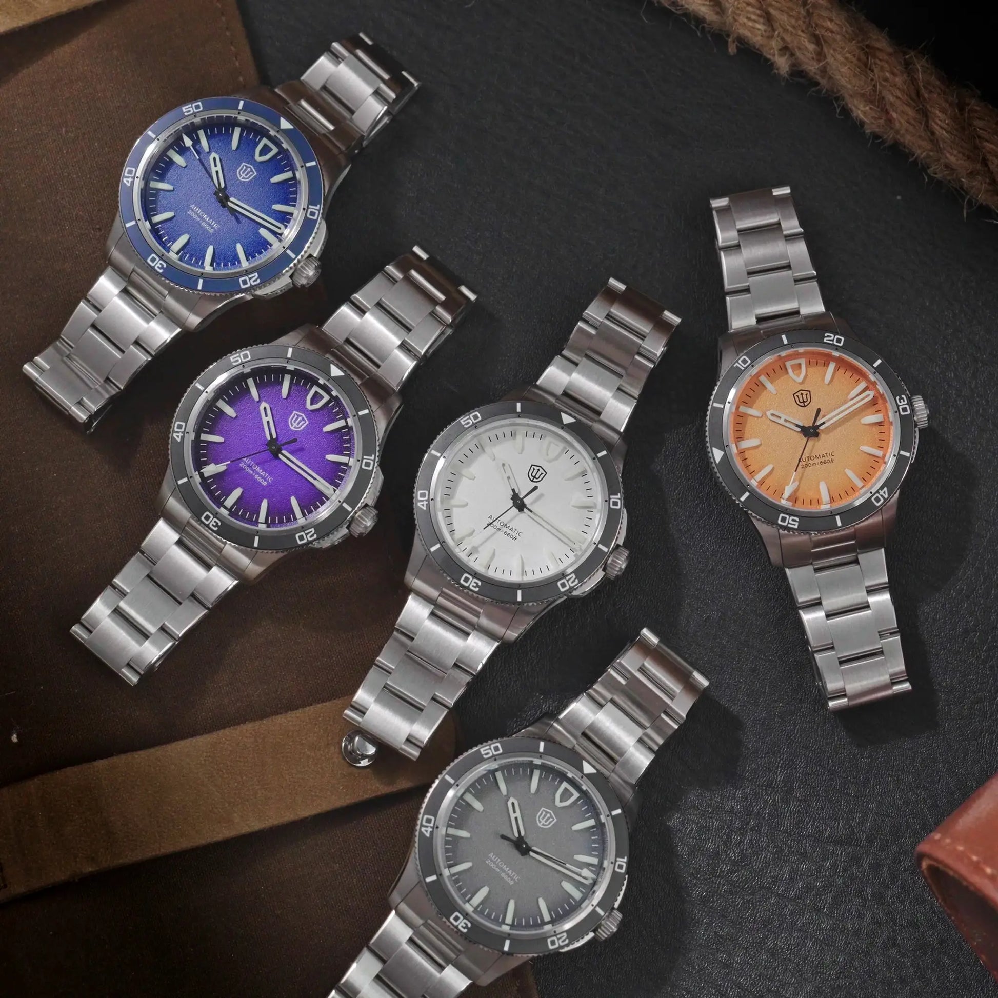 Six stainless steel diver watches from Simples Market with blue, purple, white and orange dials