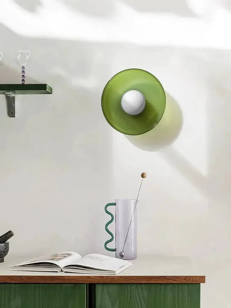 Nordic glass wall lamp with green circular shade and white bulb holder.