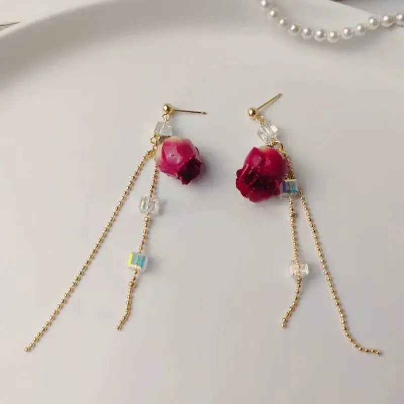 Red rose epoxy resin drop earrings pair with gold-tone chains and crystal beads
