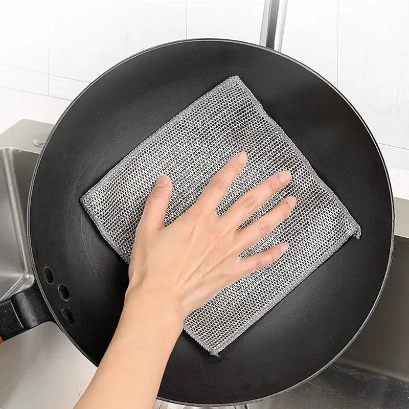 Simples Market steel wire cleaning cloth mesh scrubber used on a black non-stick pan