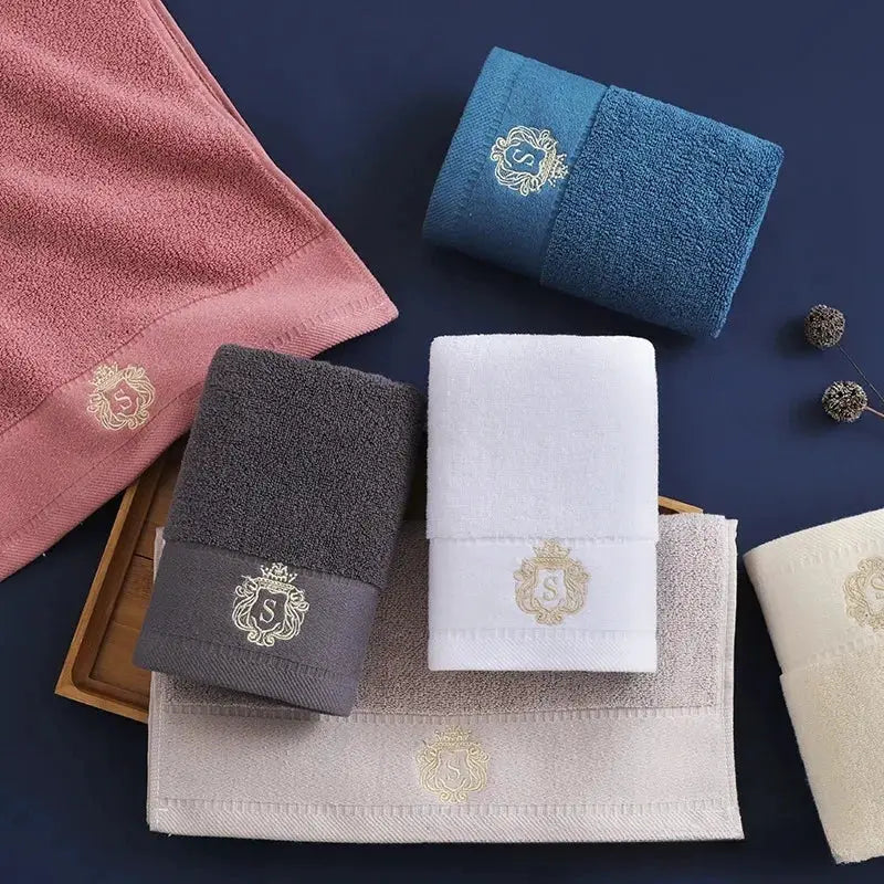 Simples Market white cotton towel set with embroidered crest; assorted towels shown.