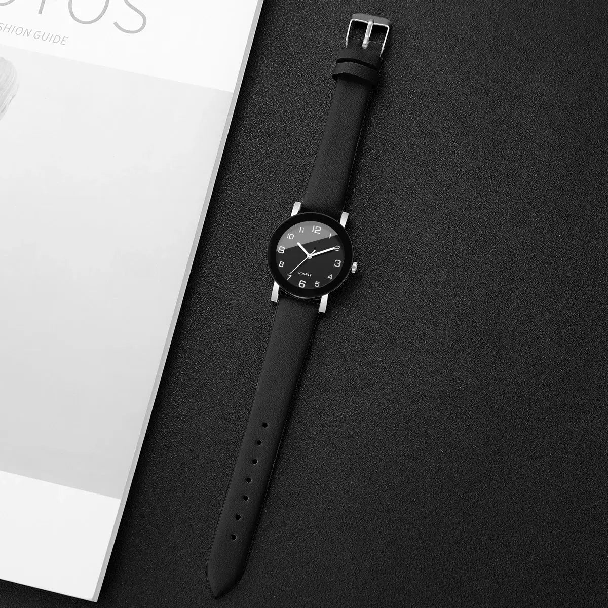 Watch by Simples Market with black leather strap, round black dial featuring Arabic numerals and quartz movement.