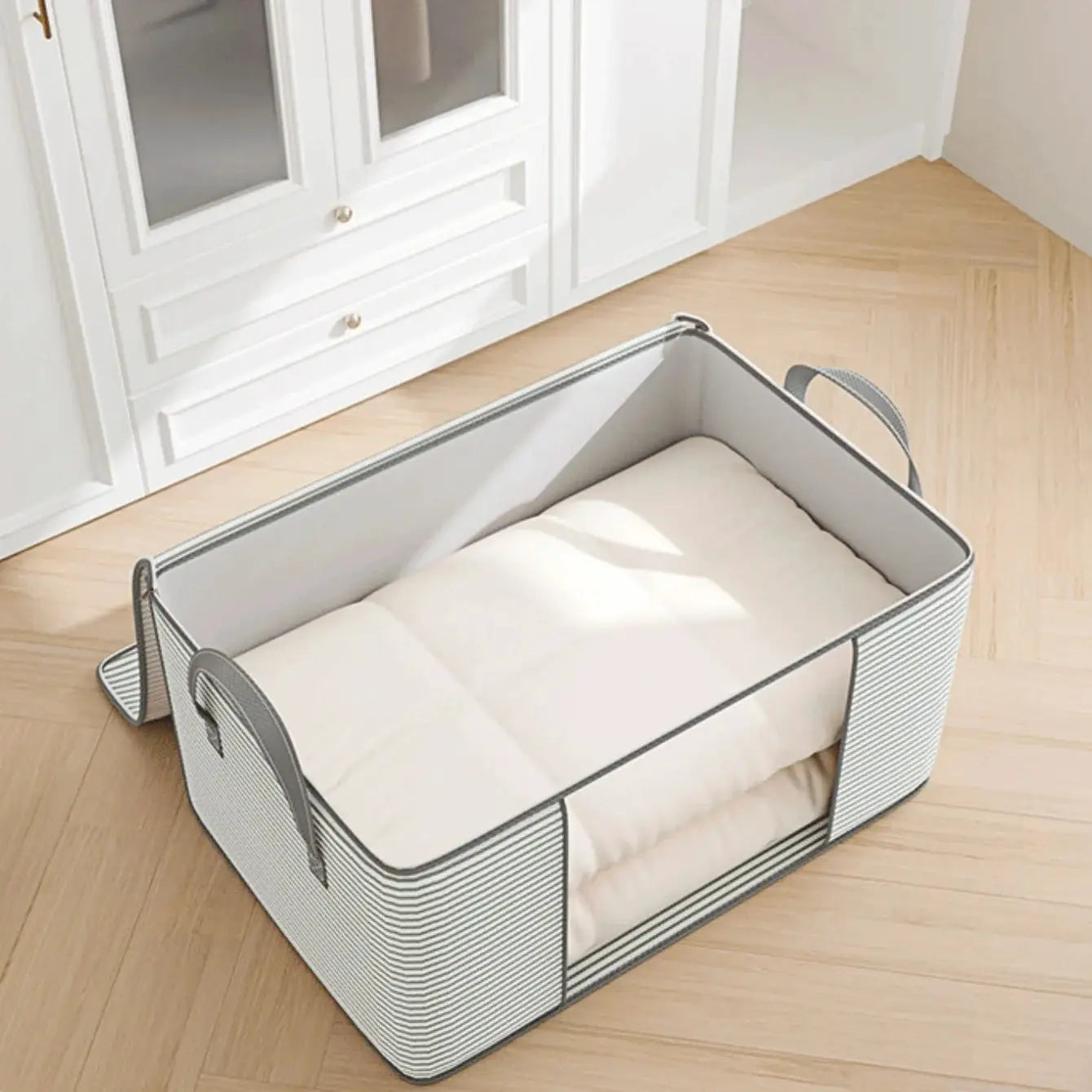 Large foldable storage bag with gray striped sides and handles; holds a white quilt.