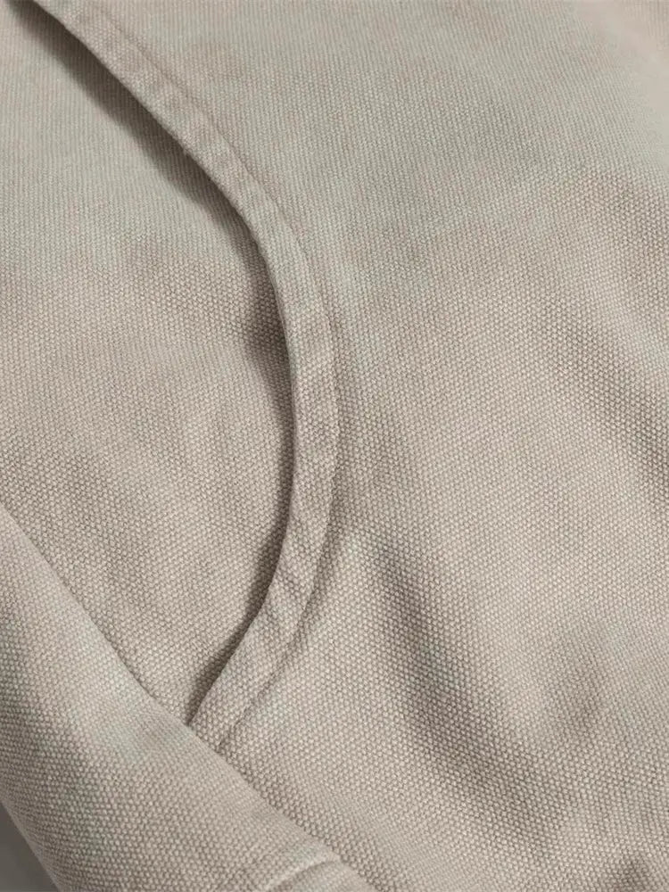 Beige canvas padded jacket fabric close-up, highlighting thick warm padding, curved seam detail, and texture
