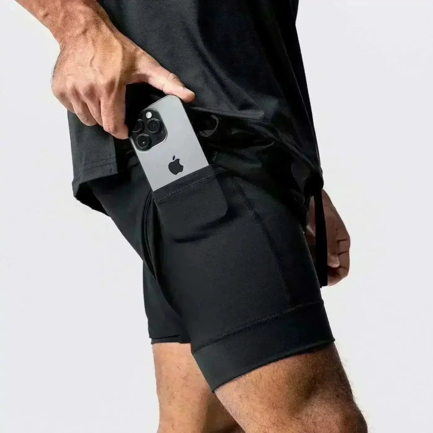 Men's black running shorts with a side pocket holding a smartphone; quick-dry gym wear.