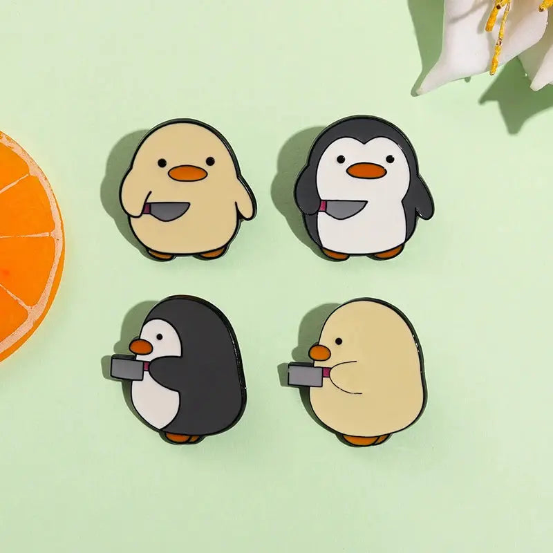 Set of 4 cartoon penguin enamel pins in beige and black with orange beaks