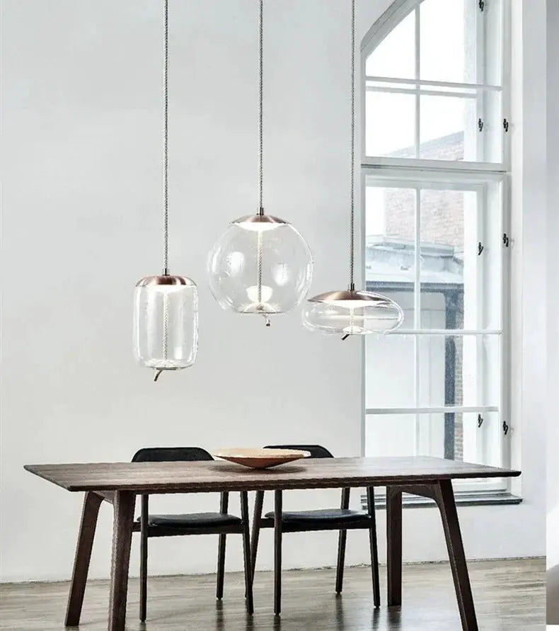 Simples Market pendant lamp set: 3 clear glass shades, copper tops, hemp rope suspensions over a wooden table