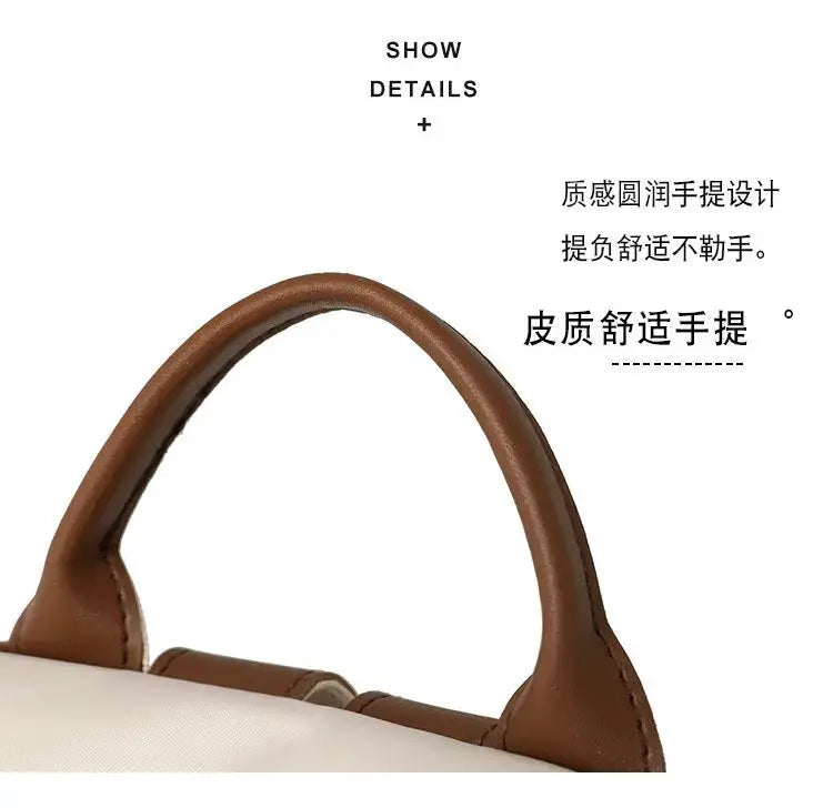 Backpack with brown leather top handles on a white nylon body
