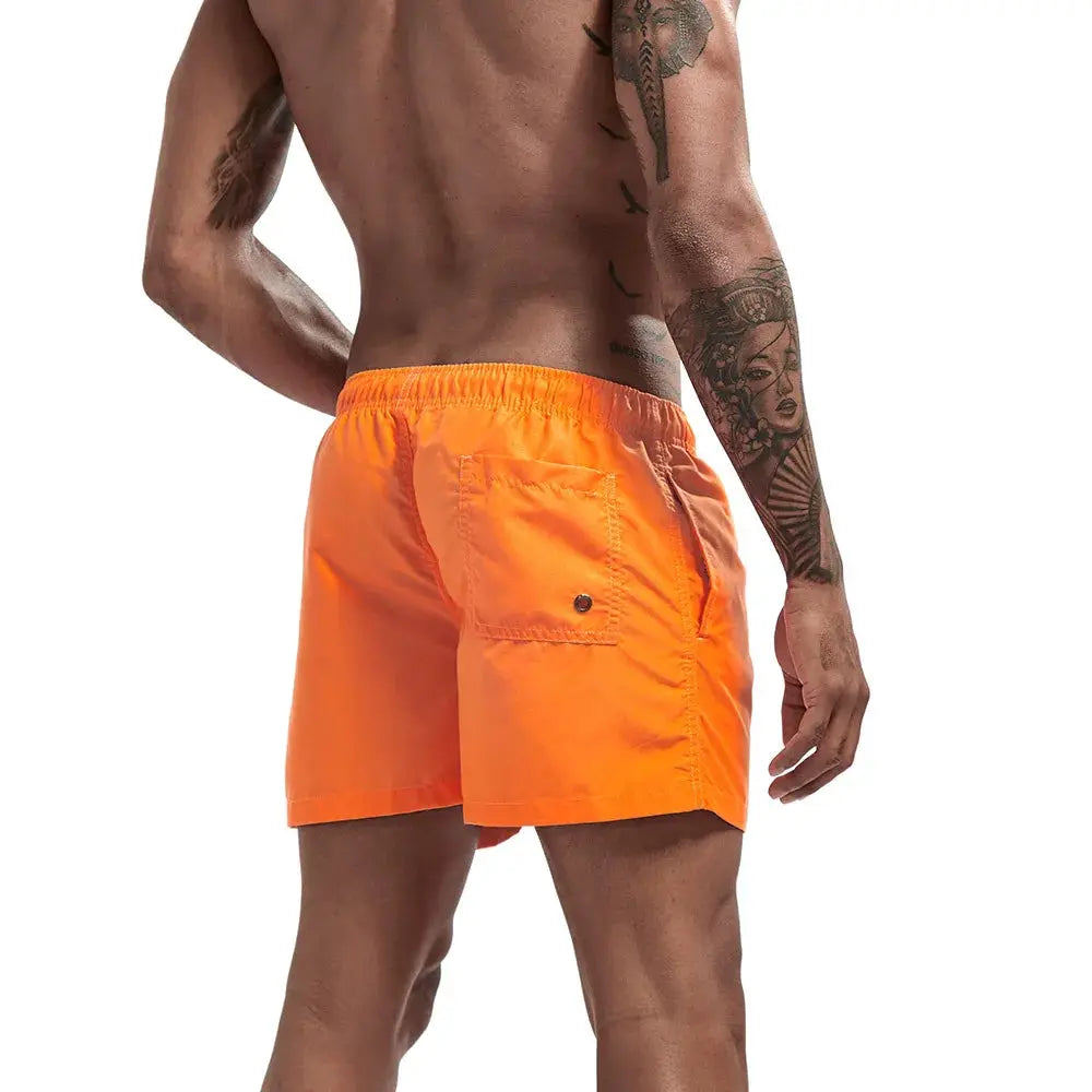 Men's orange swim shorts with elastic waistband and back pocket with button