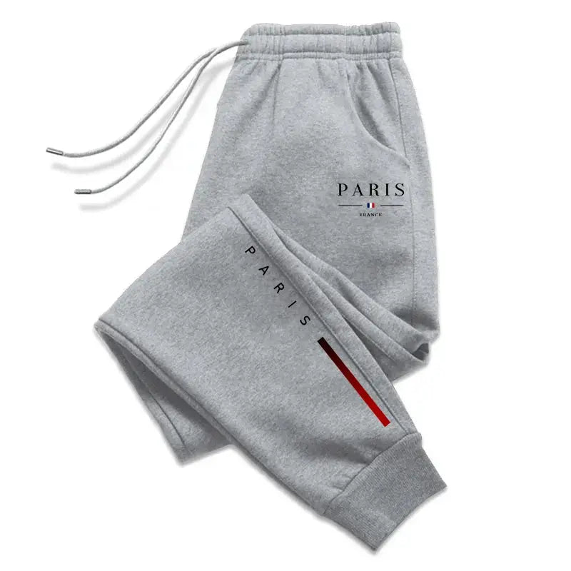 Men's grey Paris-printed sweatpants with drawstring waist and cuffed ankles, red stripe detail.