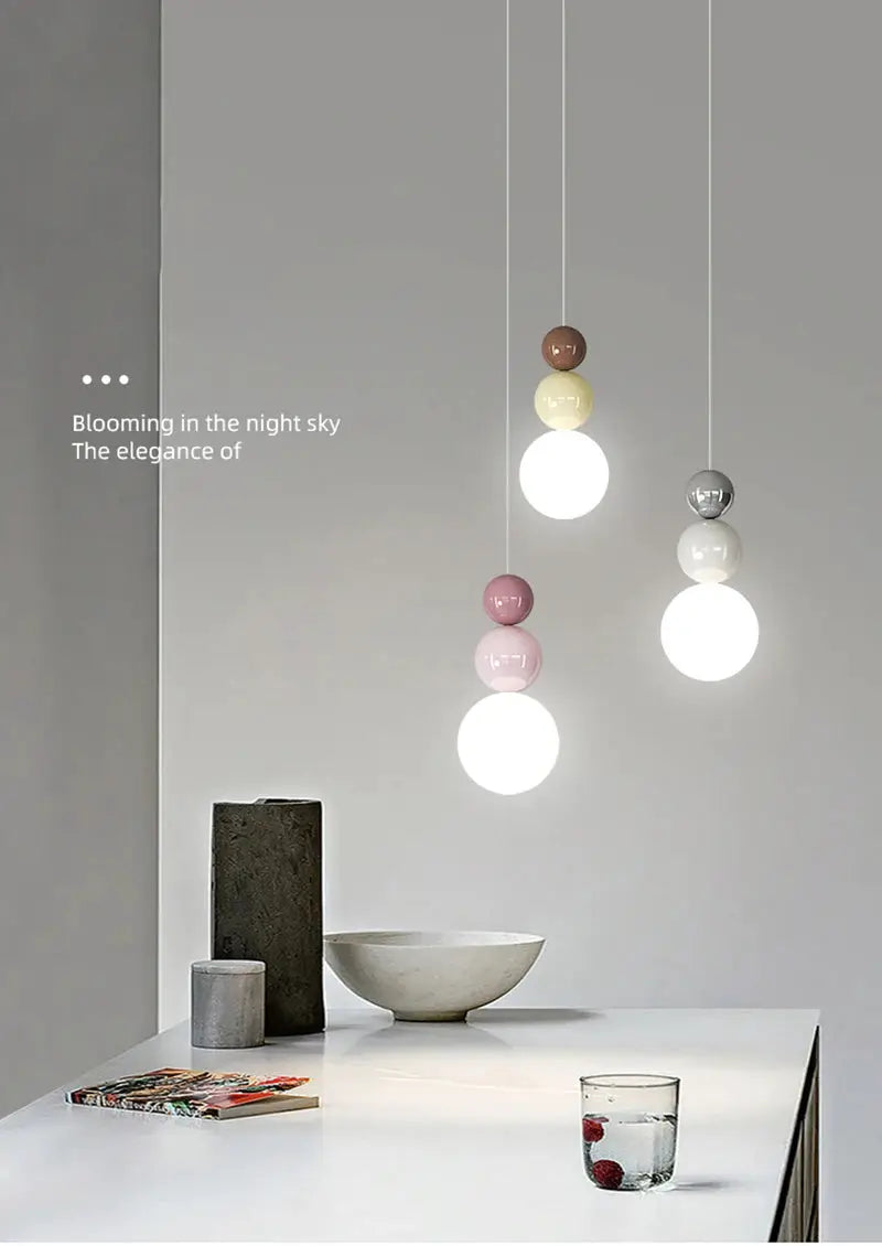 Nordic pendant light trio, modern LED hanging lamps with stacked pastel glass beads and glowing white bulbs.