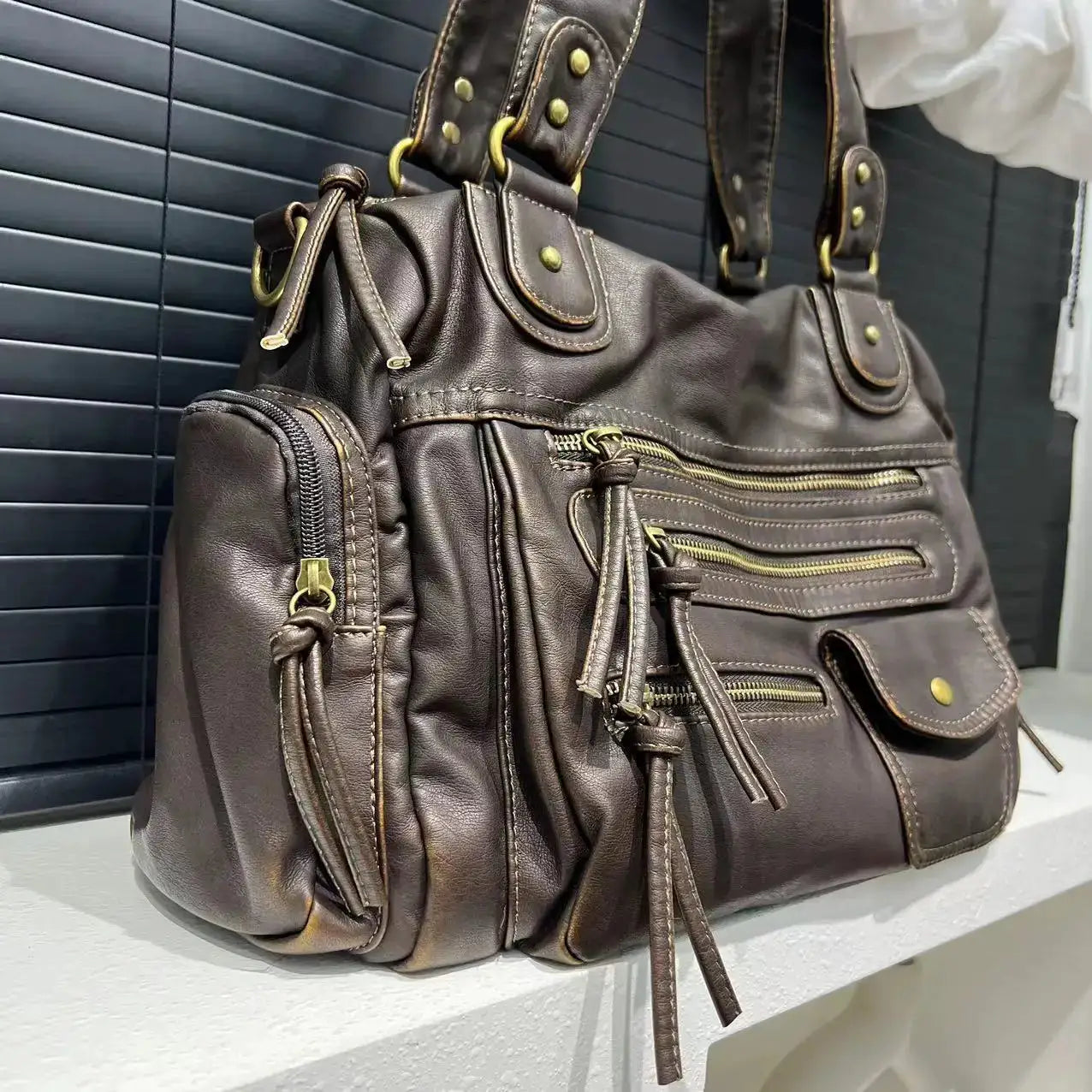 Y2K Hot Girl single-shoulder crossbody bag by Simples Market; washed brown leather with multiple zip pockets.