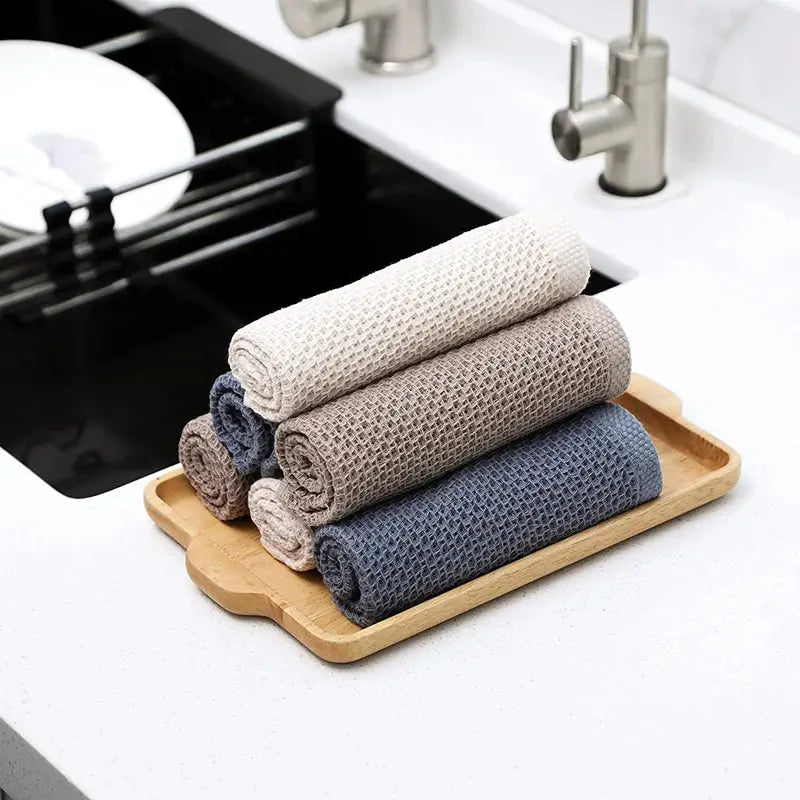 Dishcloth set: four rolled 100% cotton towels in cream, taupe, beige and navy on a wooden tray