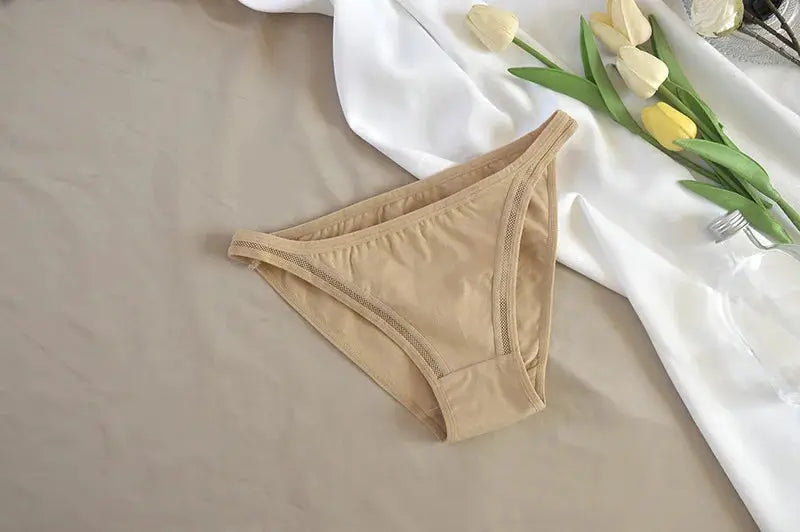 Beige women's cotton bikini panties on a neutral backdrop