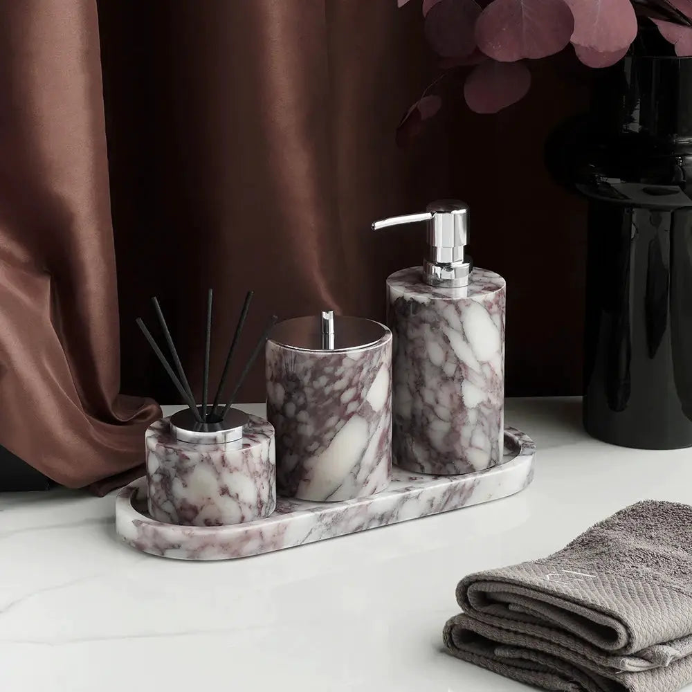 3-piece Calacatta Viola violet marble bathroom accessories set with soap dispenser, cotton swabs jar, and tray.