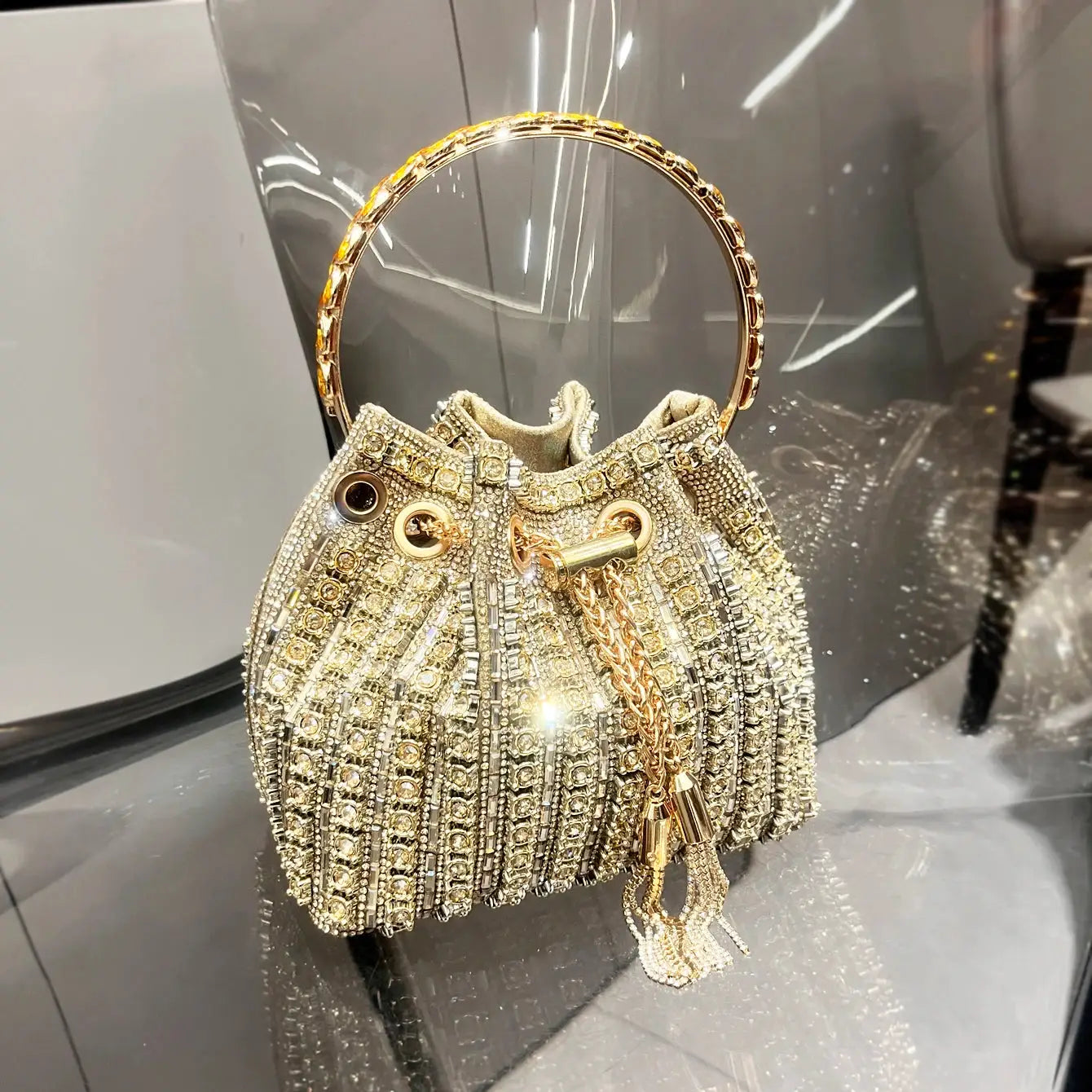 Crystal rhinestone bucket bag by Simples Market with gold ring handle for evenings