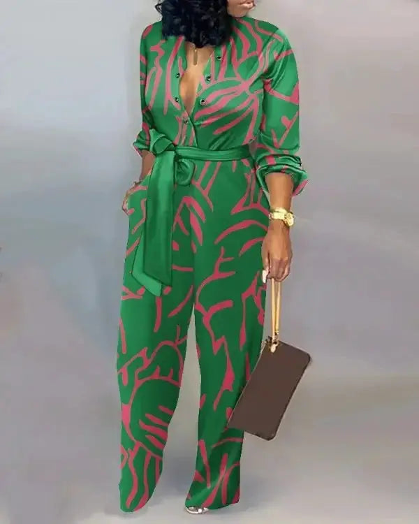 Women's green letter-print long-sleeve jumpsuit with pink abstract pattern, belted waist and button-front