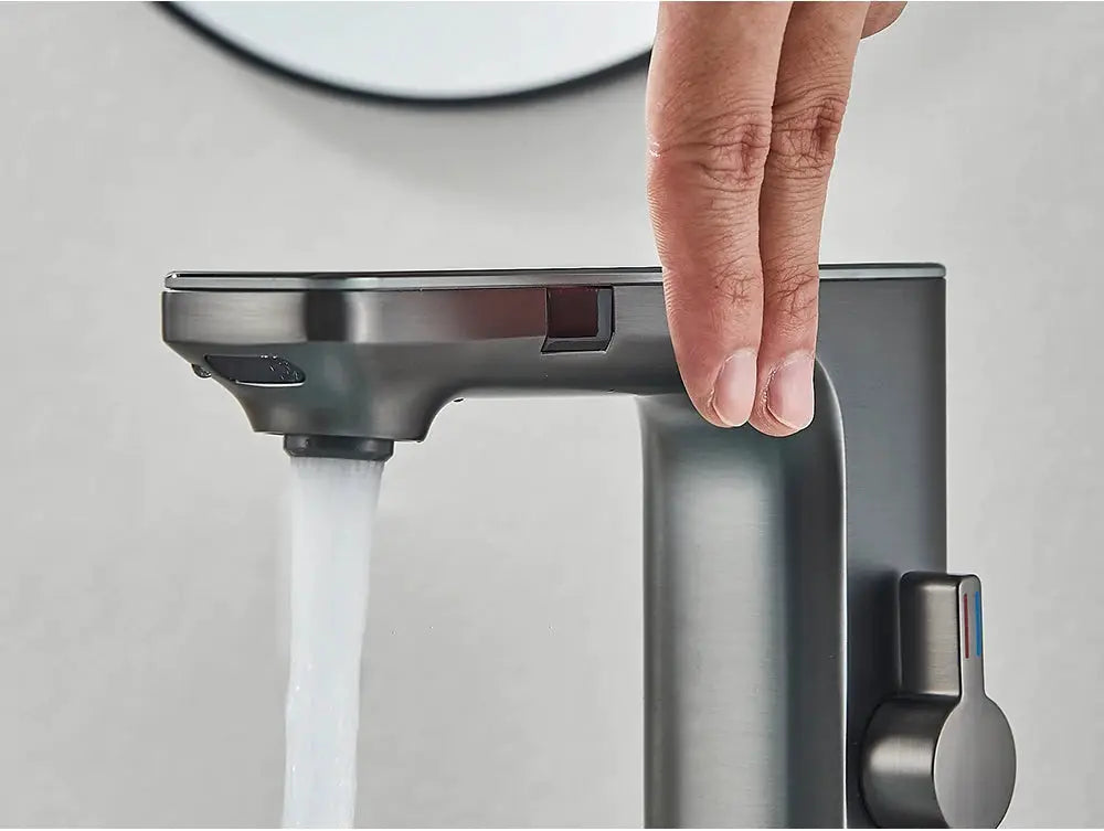 Basin faucet in brushed-nickel finish with side lever, water flowing from a modern bathroom tap.