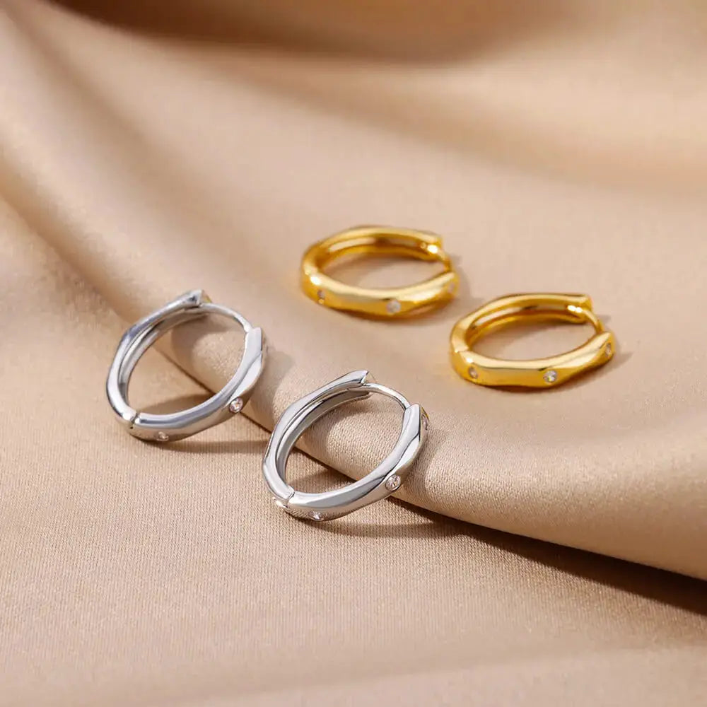 Round hoop earrings in silver and gold tones with crystal accents
