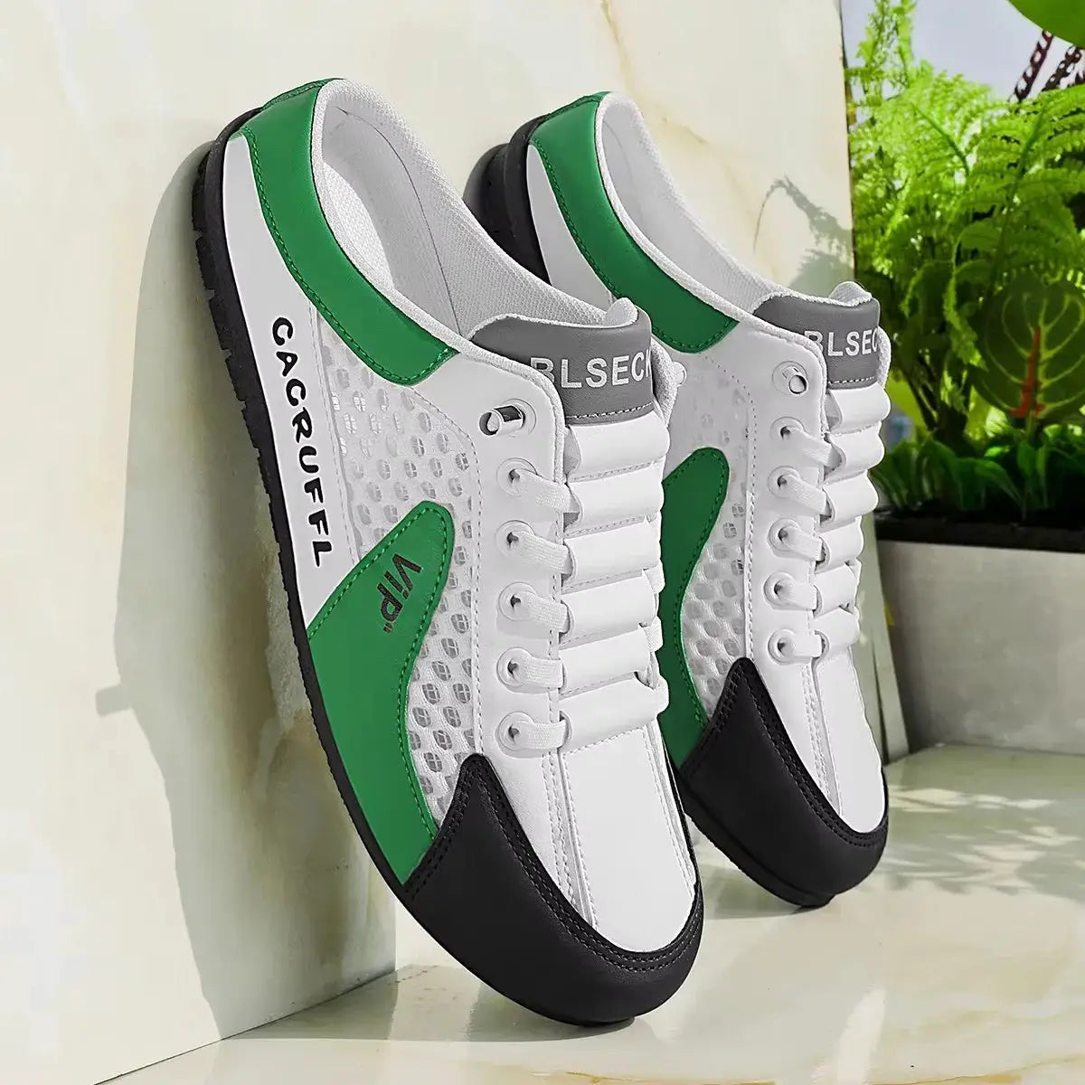 Pair of men's casual slip-on sneakers in white with green overlays, breathable mesh panels, black toe cap