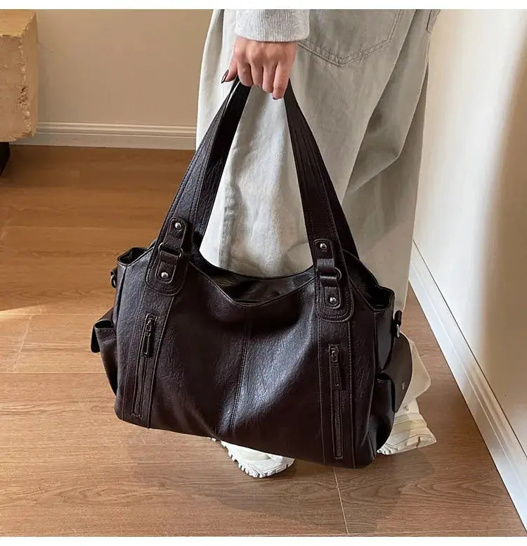 Soft interior compartment shoulder bag in black PU leather with dual top handles and zip pockets