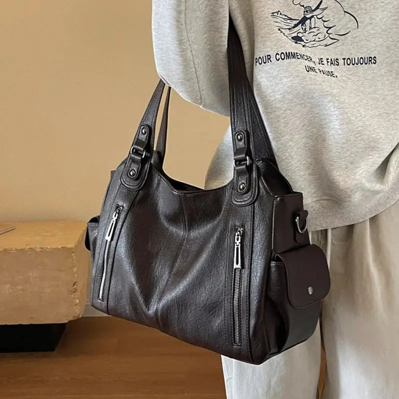 Black PU leather shoulder bag with dual top handles, front and side zip pockets, side flap pocket
