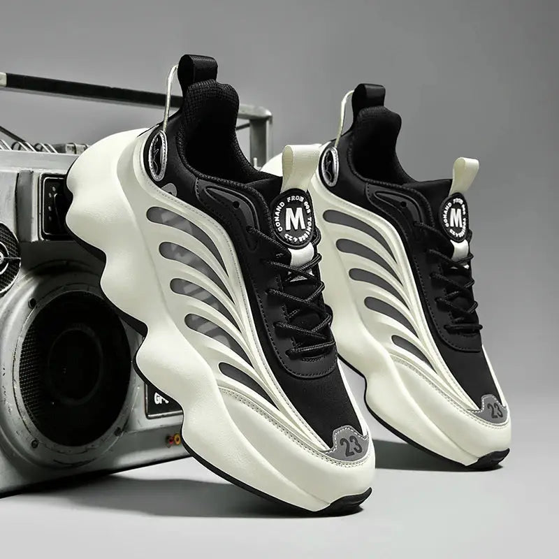Pair of men's sneakers by Simples Market in black and cream with white wave overlays and a chunky sole.