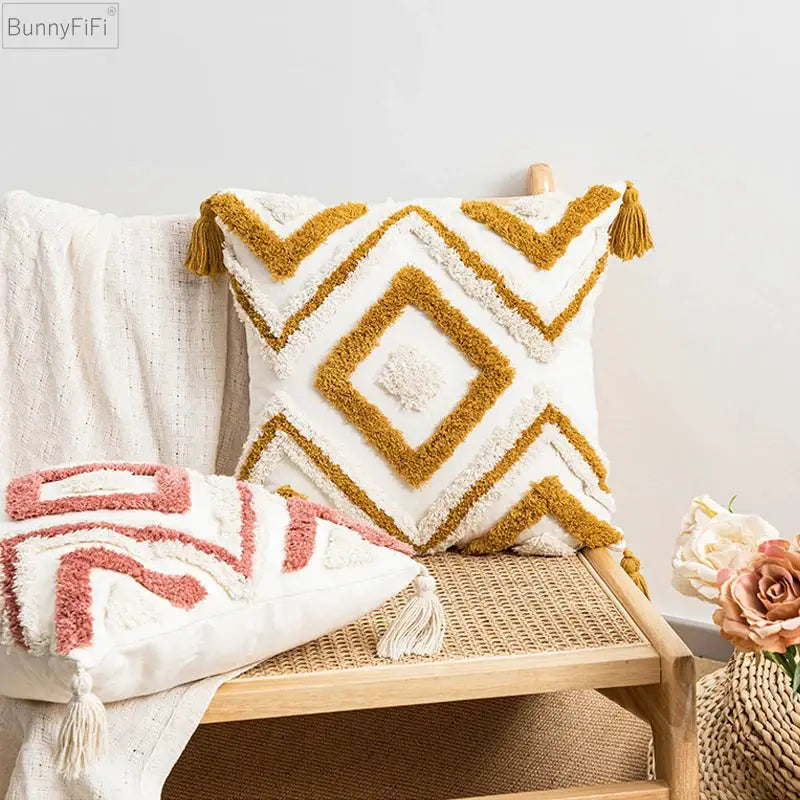 BunnyFiFi boho pillow covers set: mustard-yellow tufted diamond pillow and pink geometric pillow on a woven bench