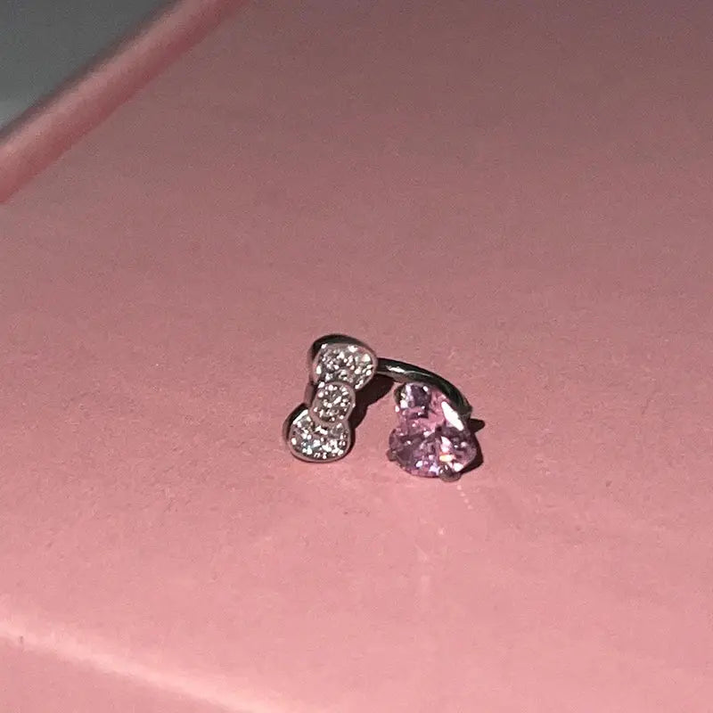 2-piece ear bone nail earrings in 316L stainless steel with bowknot zircon accents and pink heart gem