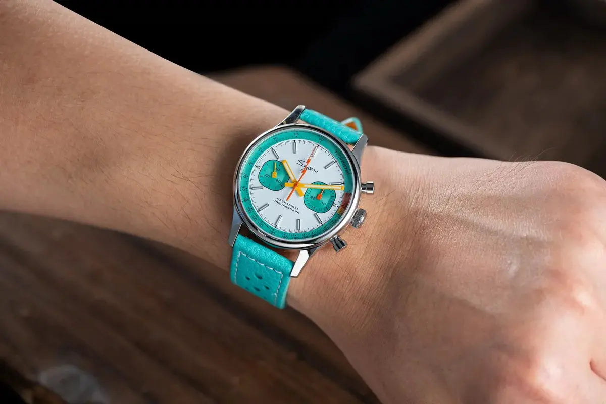 Sugess chronograph wristwatch on turquoise strap with white dial, turquoise subdials, and stainless steel case.