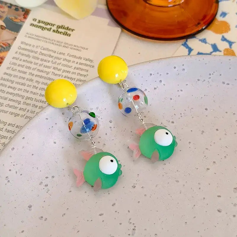 Goldfish drop earrings pair with yellow bead tops, clear dotted glass beads, and green fish charms