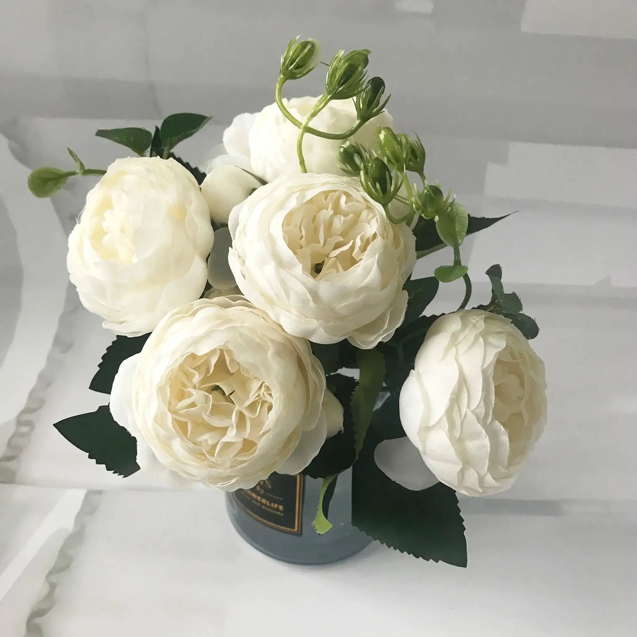 Simples Market white silk peony bouquet with 5 large blooms and 4 buds, green stems in vase