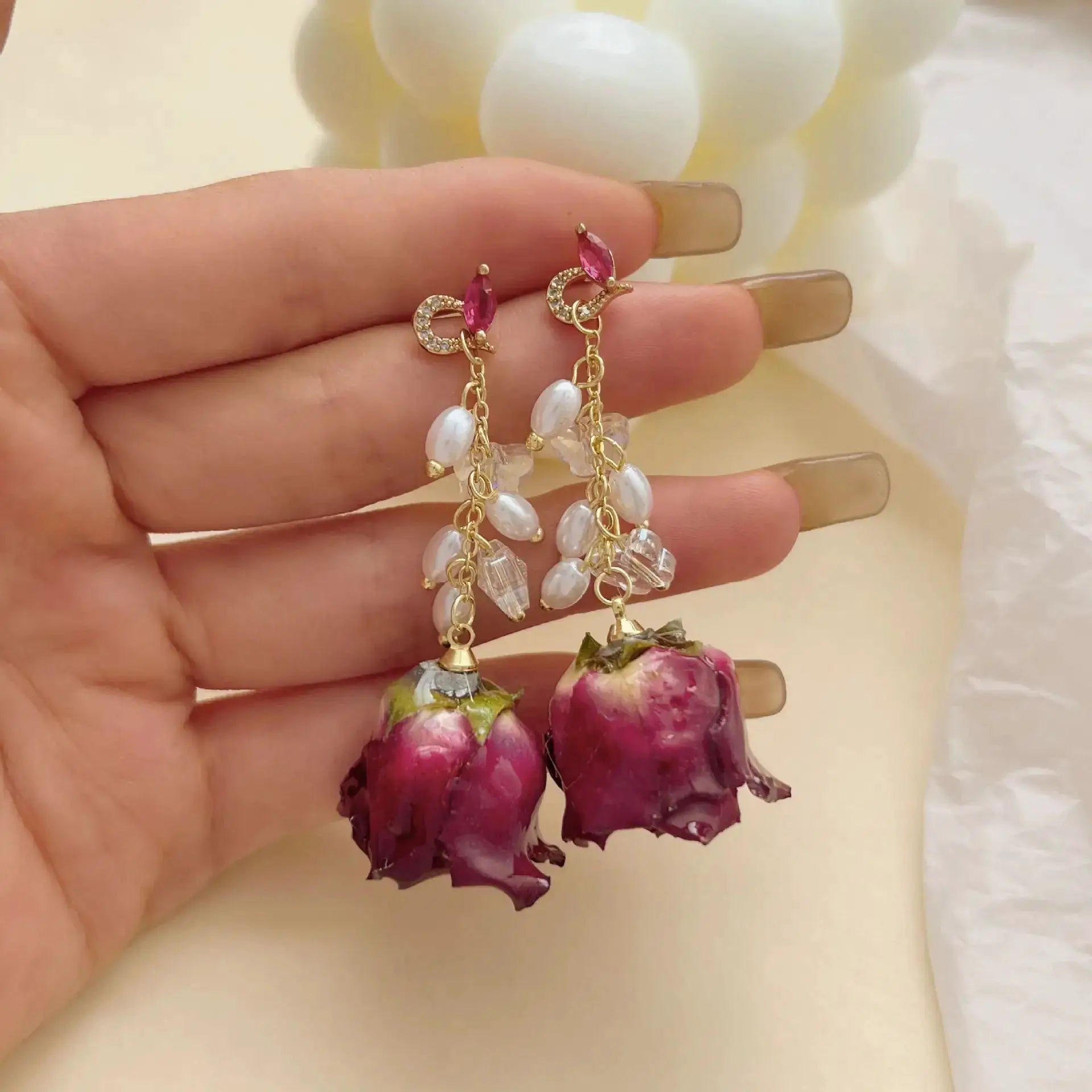 Unique red rose earrings by Simples Market; gold-tone crescent drop with pink marquise gem and pearl chains.
