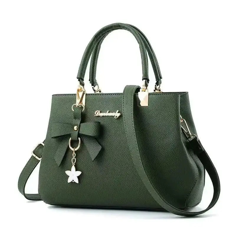 Green pebbled leather bow handbag by Simples Market with top handles and detachable shoulder strap, star charm