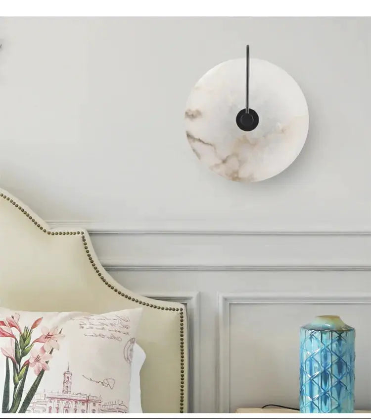 Marble moon wall sconce with black stem LED bedside light for modern bedroom decor.