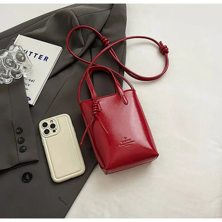 Red PU leather mini crossbody bag with dual top handles and long strap by Simples Market