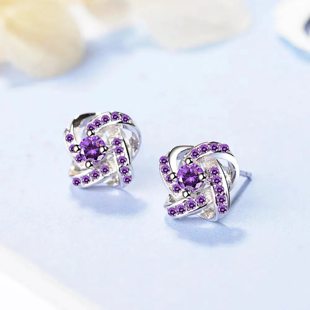 Sterling silver earrings with purple zirconia stones in a twisted heart design (pair)