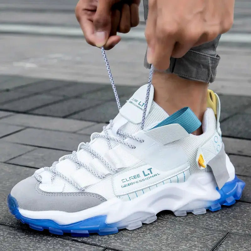 Men's white lace-up athletic sneakers with gray toe cap and blue chunky outsole
