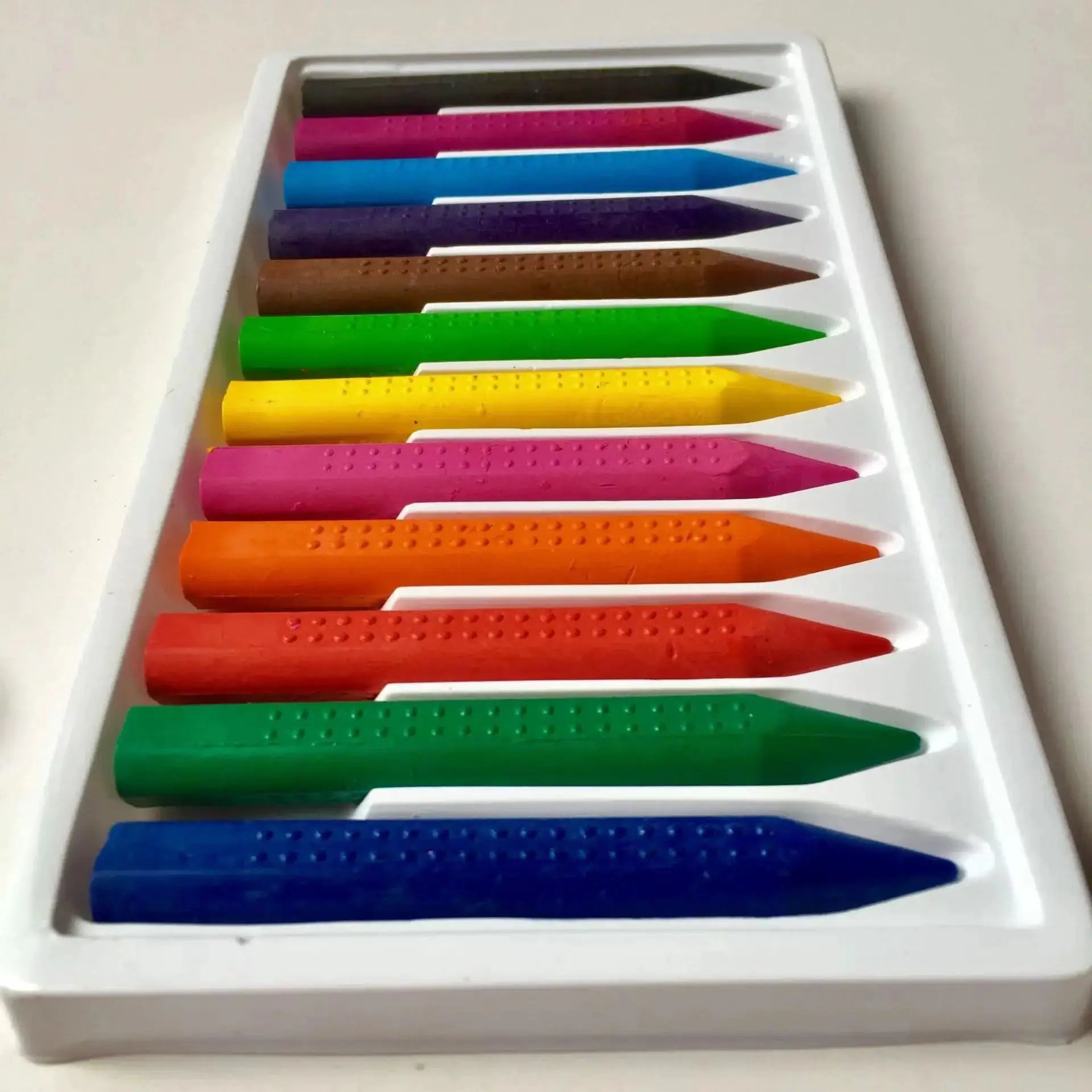 Wax crayon set by Simples Market, 12-color washable crayons in a white tray.