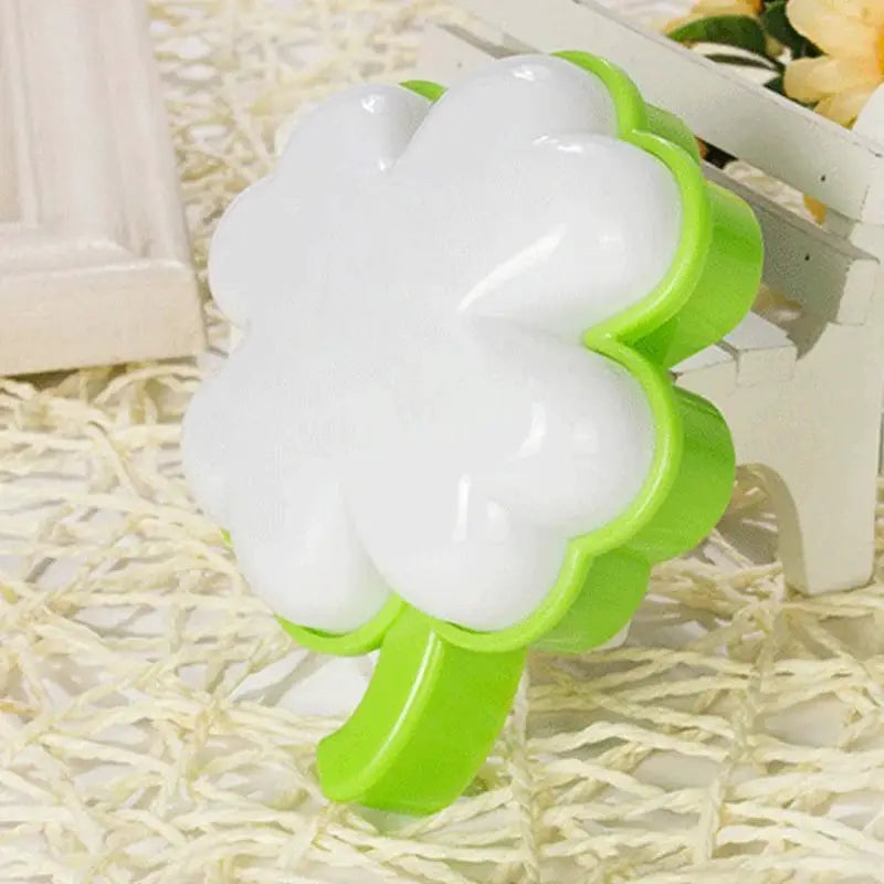 Flower-shaped LED night light with white petals and bright green plug-in base