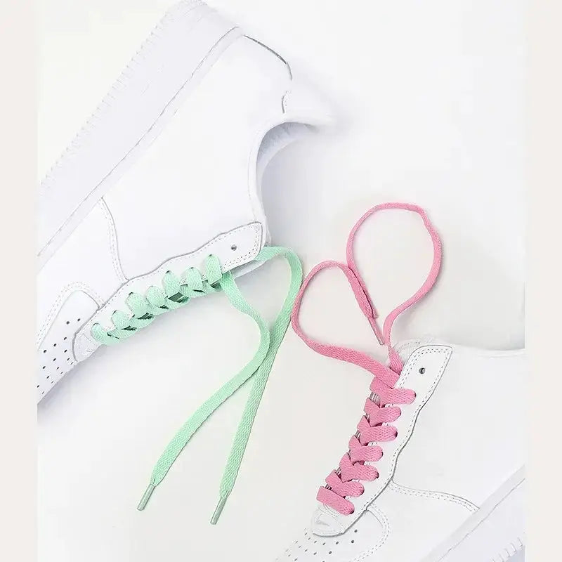 Flat shoelaces pair in mint green and pink, shown with white sneakers.