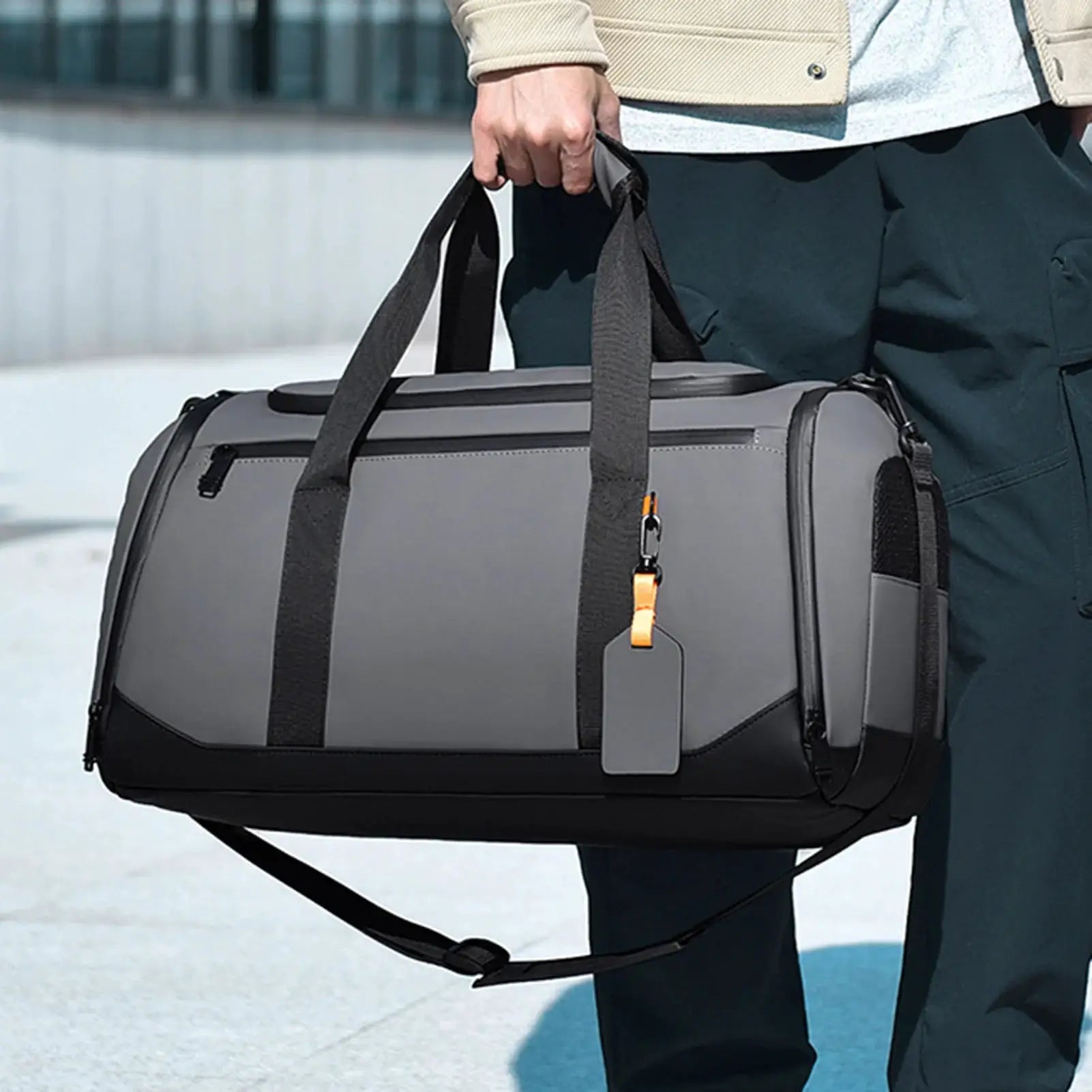 Large gray travel tote bag with multiple pockets and black handles, detachable shoulder strap